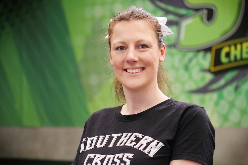 A close-up portrait of a young women wearing a t-shirt that says 'southern cross'.