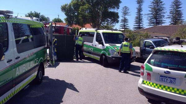 Fire and rescue crews decontaminating a man who fell through asbestos sheeting at a Cottesloe home