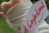 A social media post of a bandaged hand with a tag #GaylesLaw NOW!