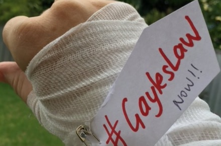 A social media post of a bandaged hand with a tag #GaylesLaw NOW!