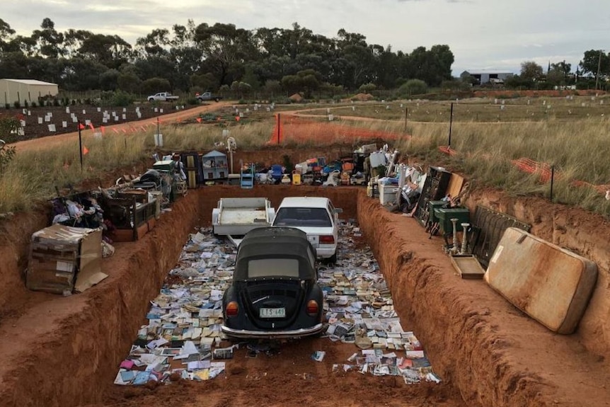 Possessions, including cars and a trailer, at the burial site as part of an art installation at an Irymple garden.