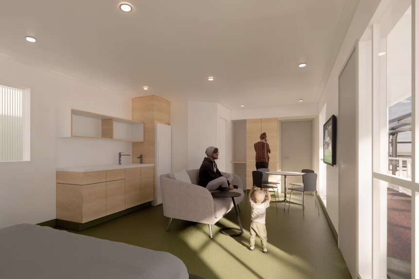 Inside a room with white walls, green carpet, and natural timber kitchenette, grey couch.