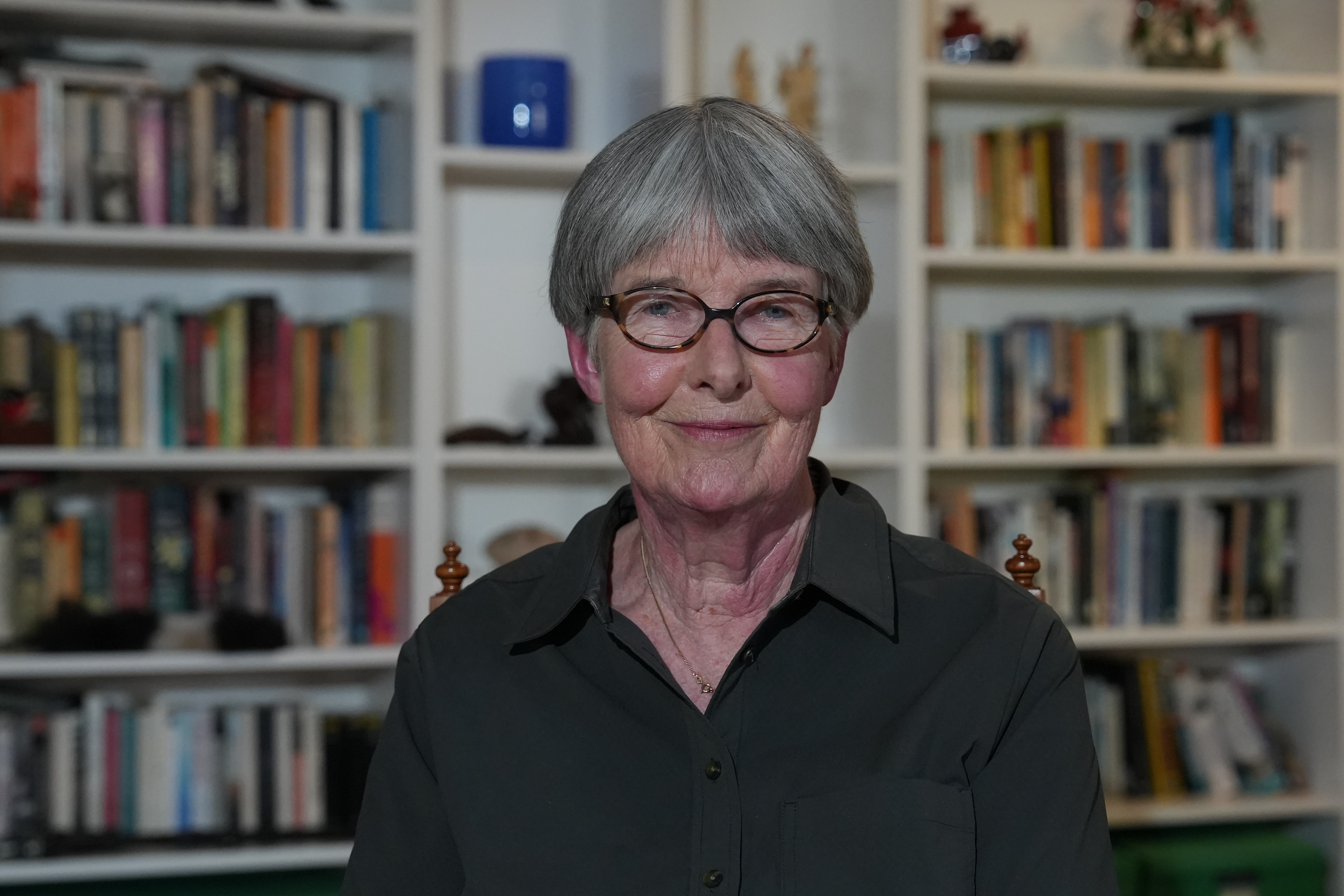 Hlen Moore sonríe frente a una estantería.