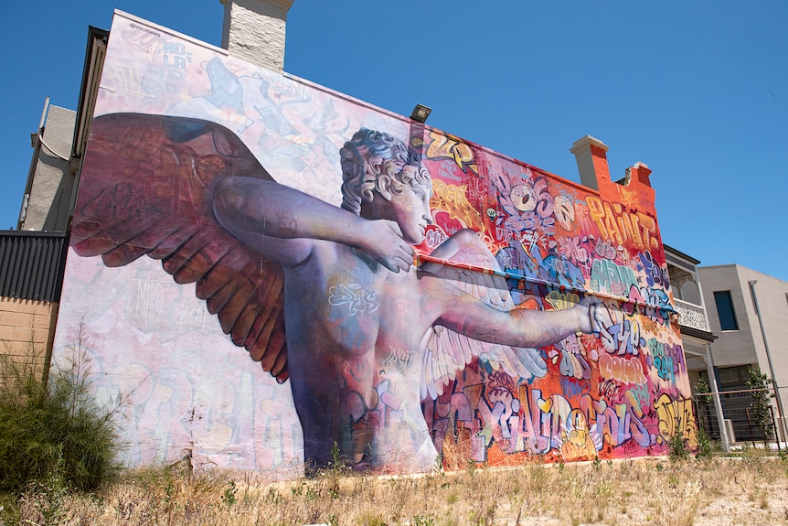 A large mural of Cupid on the side of a building.