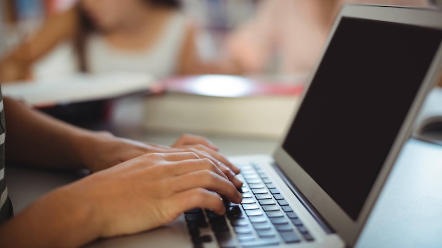 Hands at a keyboard of a laptop computer.