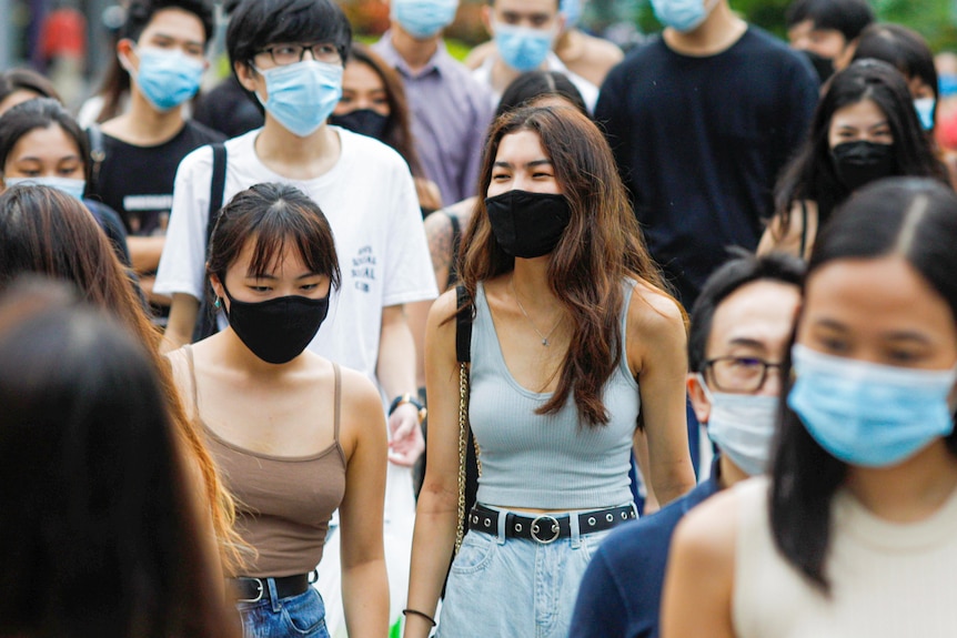 A crowded street in Singapore, where every pedestrian is wearing a mask