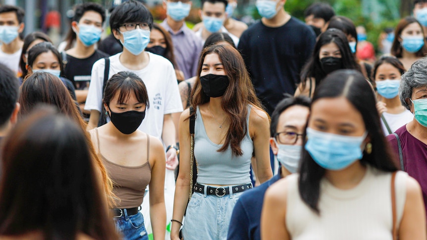 A crowded street in Singapore, where every pedestrian is wearing a mask