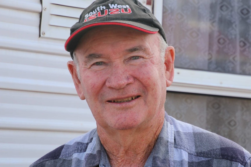 A head and shoulders shot of Gary Gulberti posing for a photo smiling wearing a black and red cap.