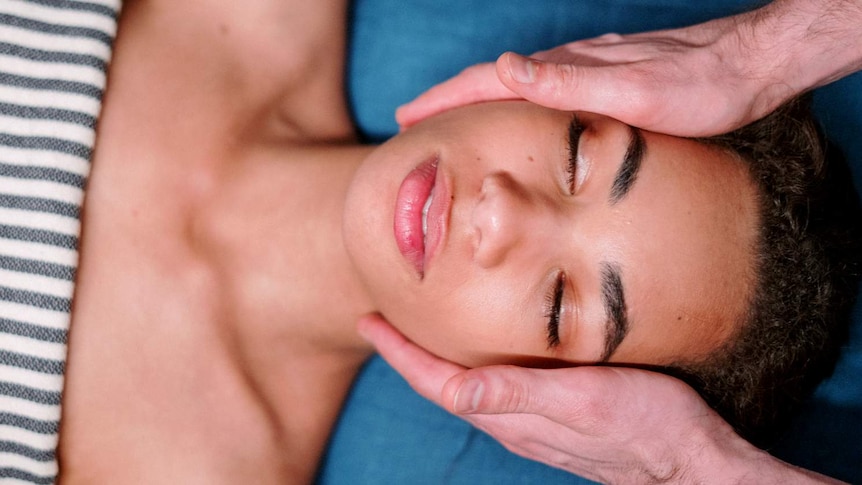 Woman having her face touched by man's hands