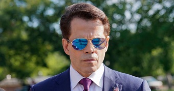 Anthony Scaramucci frowns behind dark sunglasses.