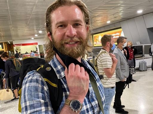 David Knoff smiles for photo at airport baggage claim