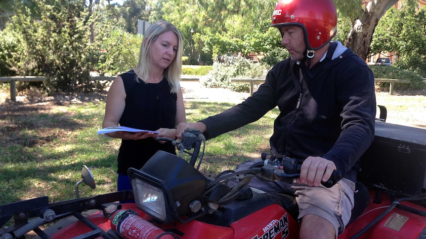 Lisa Wundersitz talks to farmer Anthony Smith, while he sits on a quad bike.