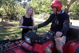 Lisa Wundersitz talks to farmer Anthony Smith, while he sits on a quad bike.
