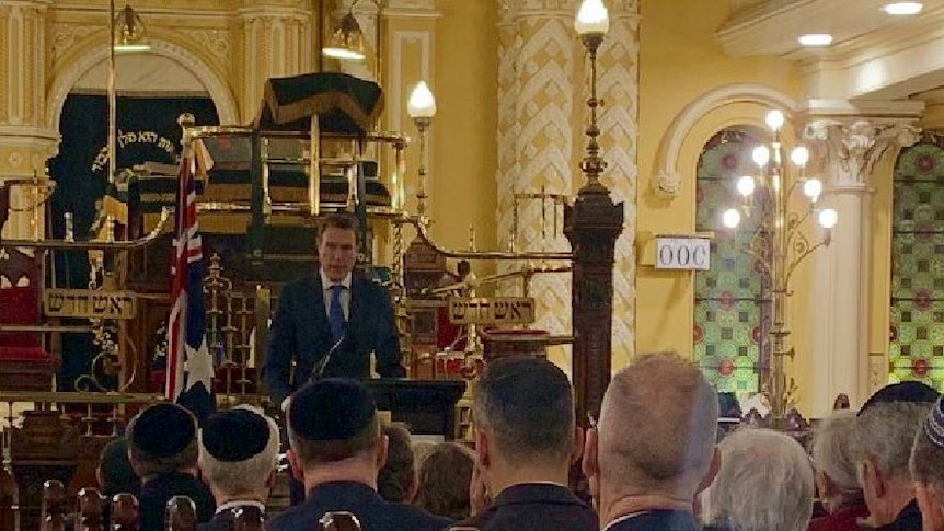 Christian Porter speaking at the Great Synagogue in Sydney with the backs of the congregation.