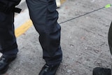 An arrow protrudes from the leg of a Hong Kong policeman.