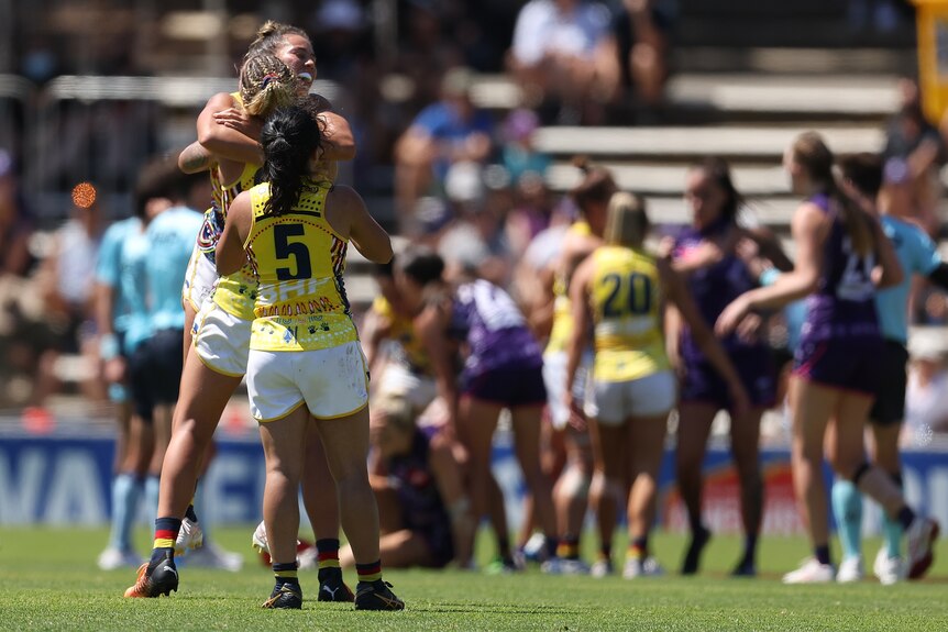 Adelaide Crows AFLW players embrace after beating Fremantle