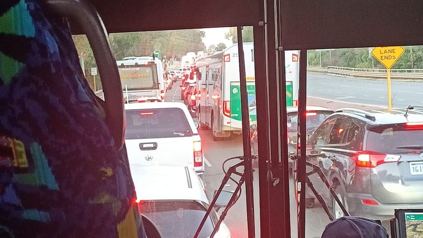 View from inside a bus stuck in heavy traffic with other cars and busses