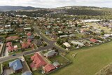 A birds eye view of houses and schools next door to a paddock.