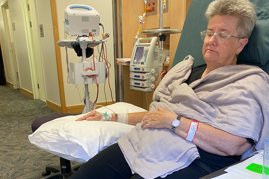 Therese McLean sits and rests in an armchair attached to intravenous drugs.