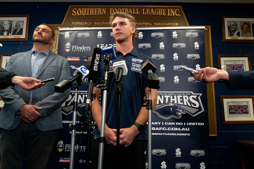 Jason Horne-Francis stands behind microphones at the South Adelaide Football Club