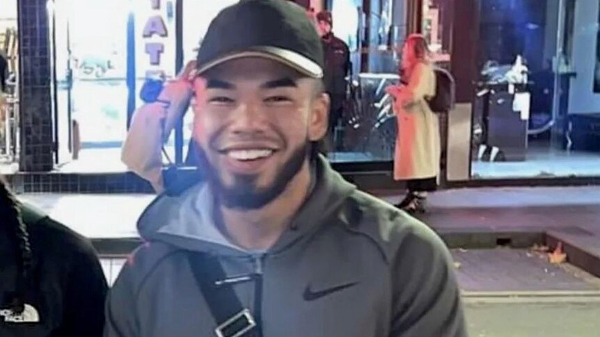 Twenty-year-old Johnson Kokozian wearing a cap looking at the camera and smiling