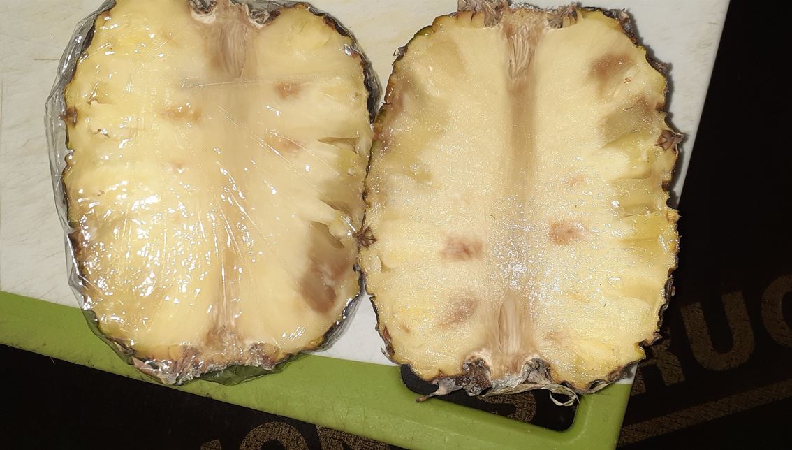 Una piña cortada por la mitad mostrando imperfecciones.