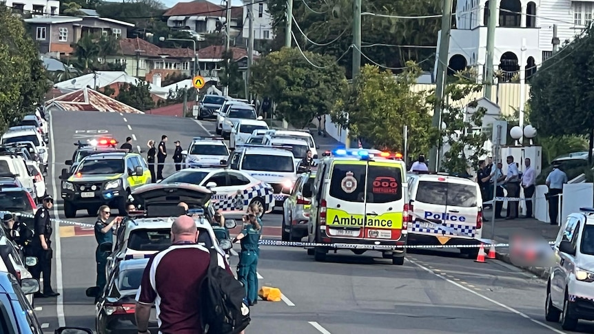 Ambulance and police at scene of shooting in South Brisbane, police tape and vehicles closing the road
