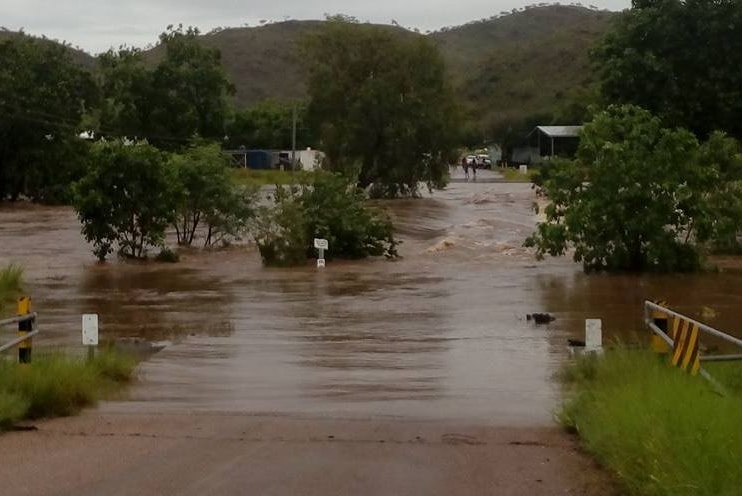 An outback town is cut in half by red dirt floodwaters