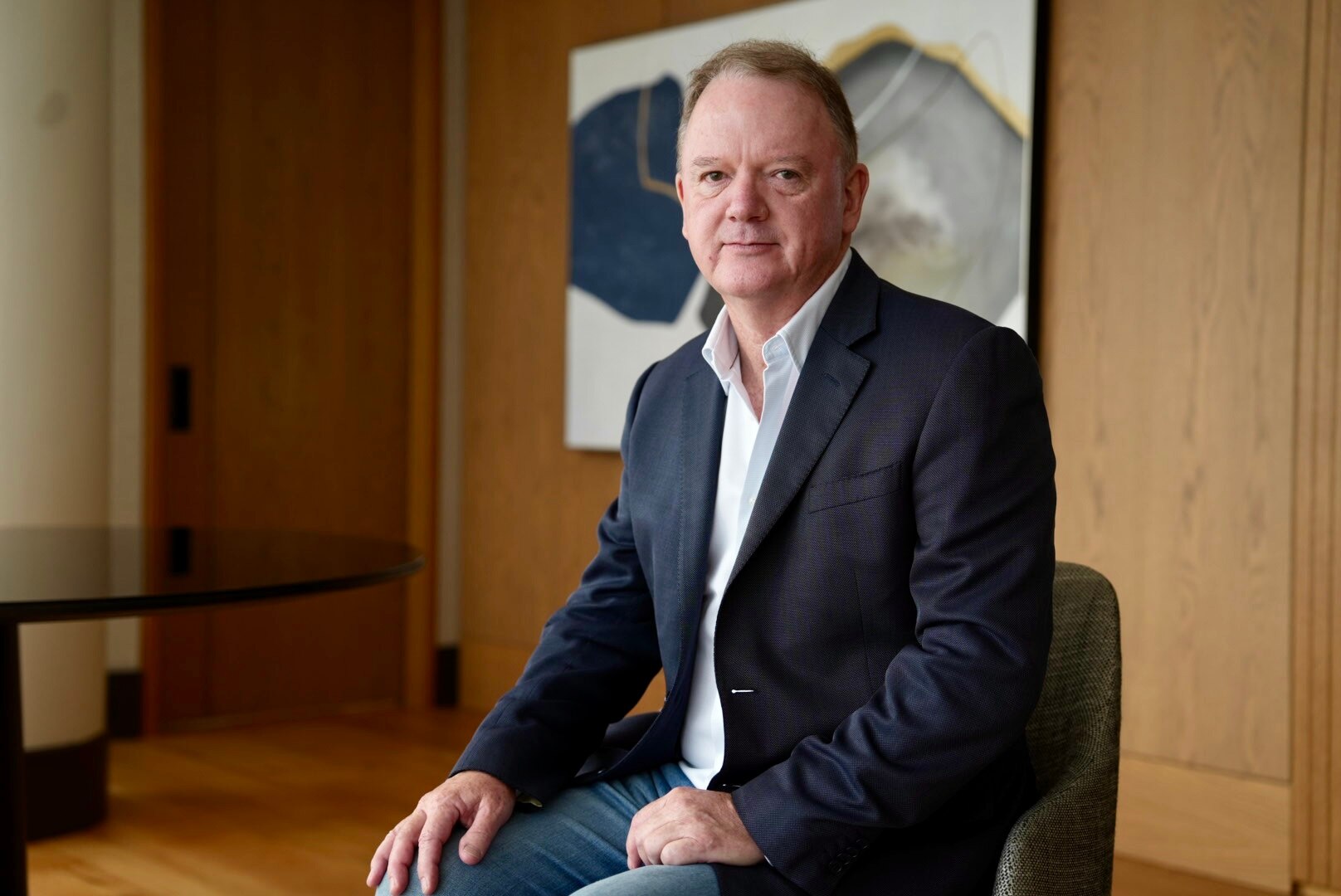 A portrait photo of Peter Coleman sitting in a wood-panneled office