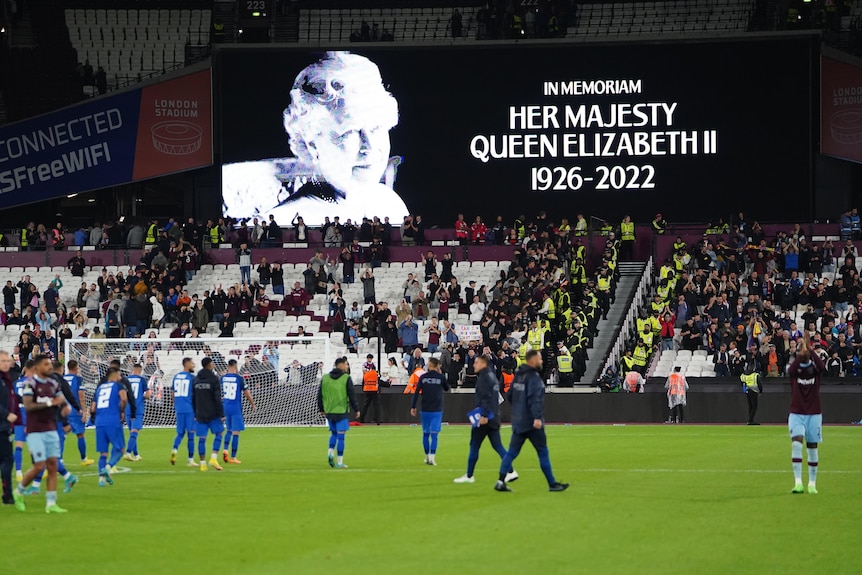 A sign honouring the Queen is shown inside a football stadium
