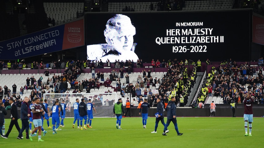 A sign honouring the Queen is shown inside a football stadium