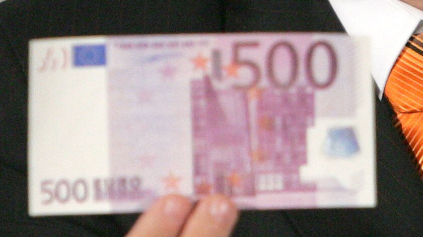 A hand holds a 500 Euro note