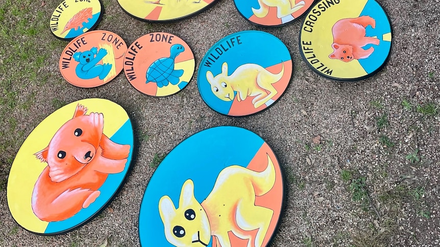 A pile of blue and yellow signs featuring kangaroos and wombats.
