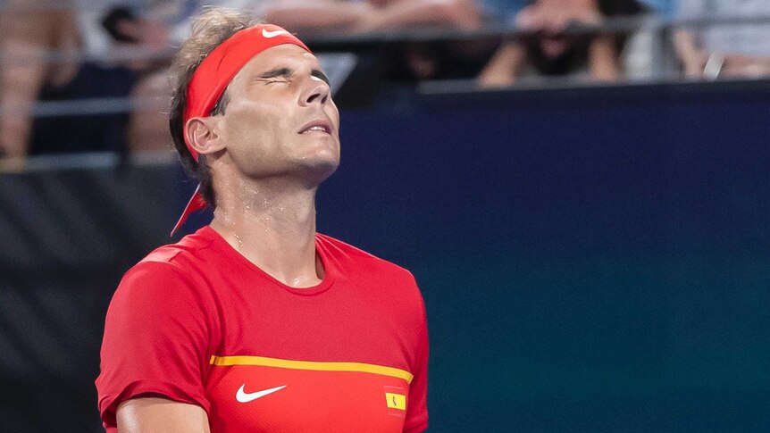 Spain tennis star Rafael Nadal closes his eyes and winces during a match at the ATP Cup.