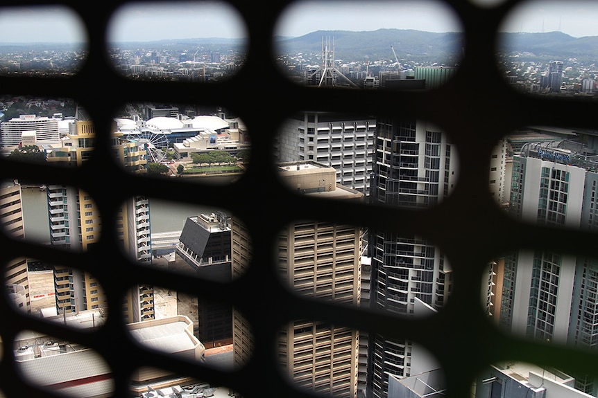 View over south Brisbane through the metal lattice of a building's lift.