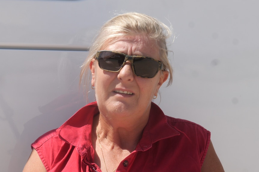 A woman in a red shirt and sunglasses 