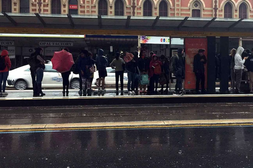 Commuters wait for trams in Adelaide.