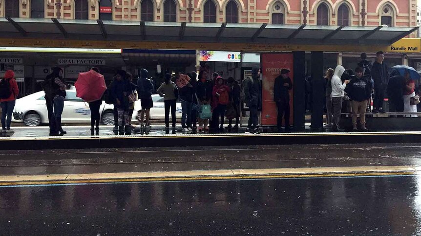 Commuters wait for trams in Adelaide.