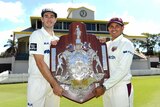 Kurtis Patterson and Usman Khawaja, wearing their playing whites, smile while holding the Sheffield Shield