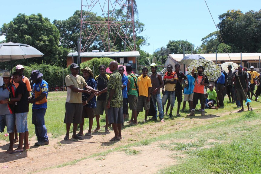 Residents of Papua New Guinea's Daru Island congregate in the street.