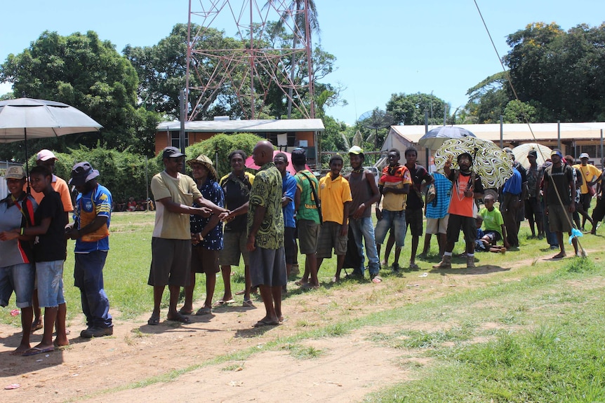 Residents of Papua New Guinea's Daru Island congregate in the street.