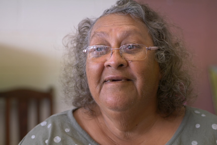 Portrait of Susan Merry, wearing reading glasses glancing slightly off camera.