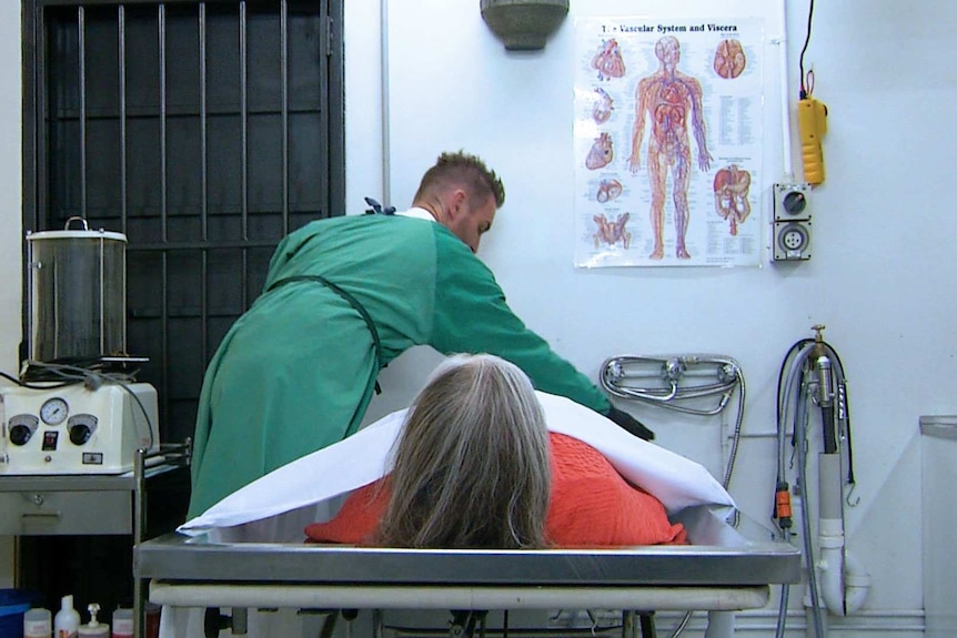 Embalmer Michael Cox prepares a dead body in his mortuary.