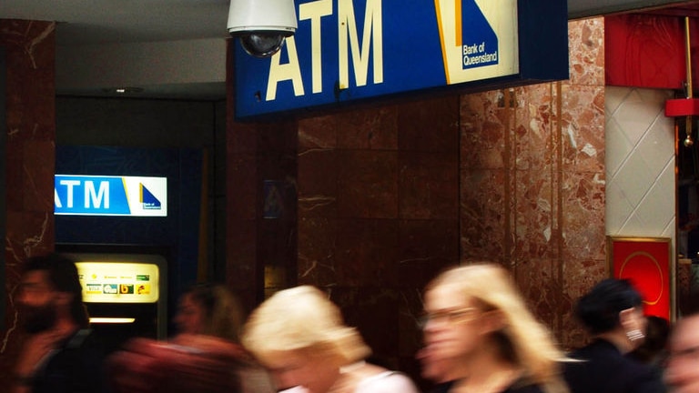 Pedestrians walk past a Bank of Queensland branch