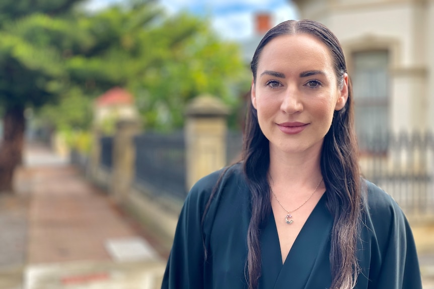 Courtney Roger stands on footpath with row of houses behind her