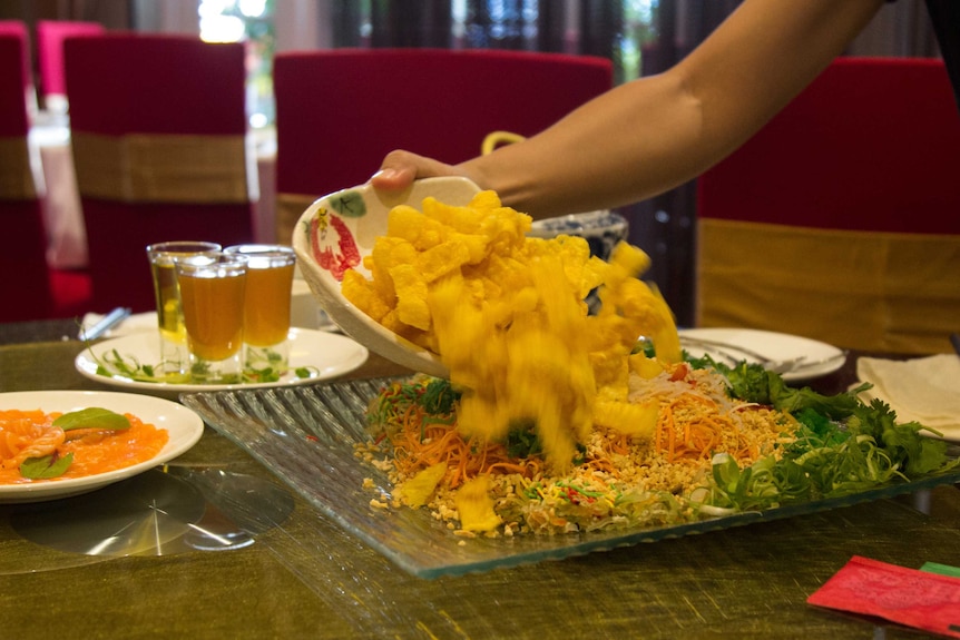 Mixing the Yusheng at the table is part of the tradition