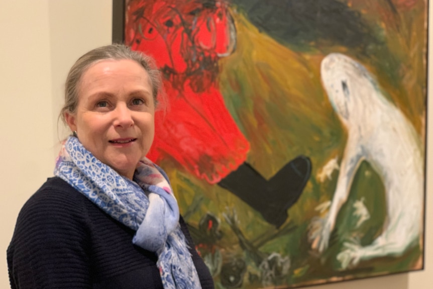 A woman in front of an Arthur Boyd painting.