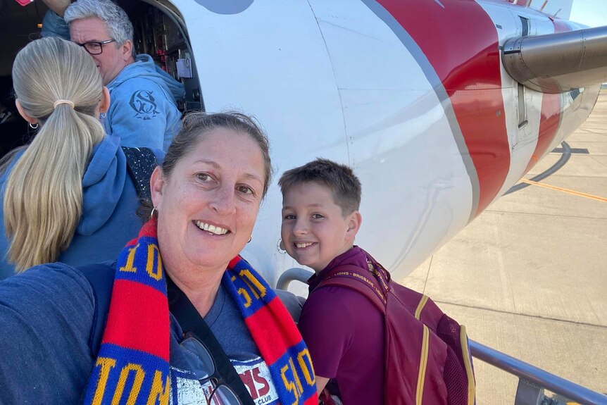 A selfie of Naomi Thompson and her son next to a plane