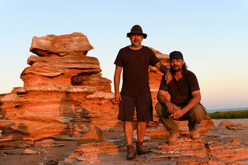 Directors Wayne Blair and Warwick Thornton posing in front of a red rock formation in Western Australia