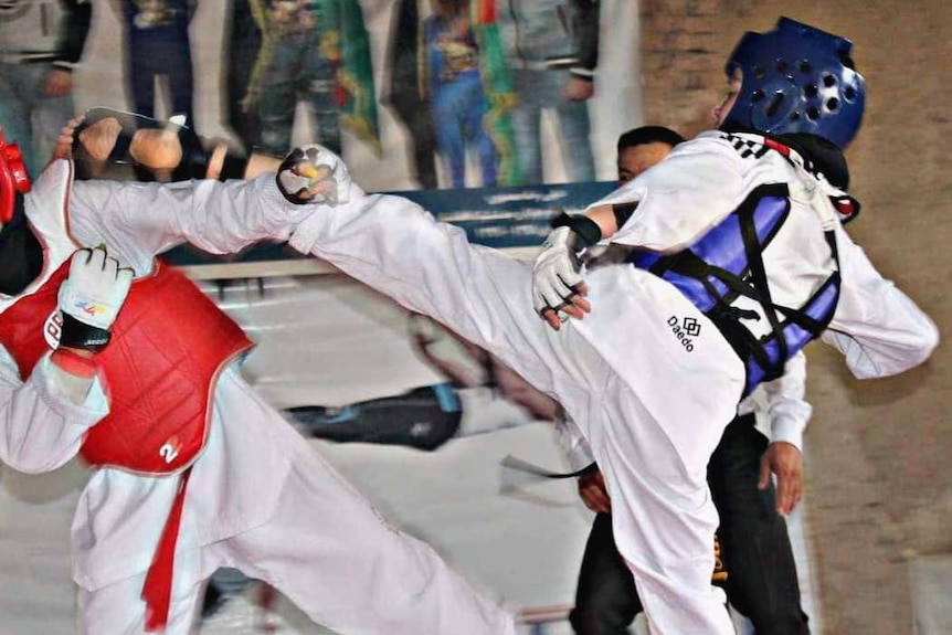 Two taekwondo athlete competing against one another 